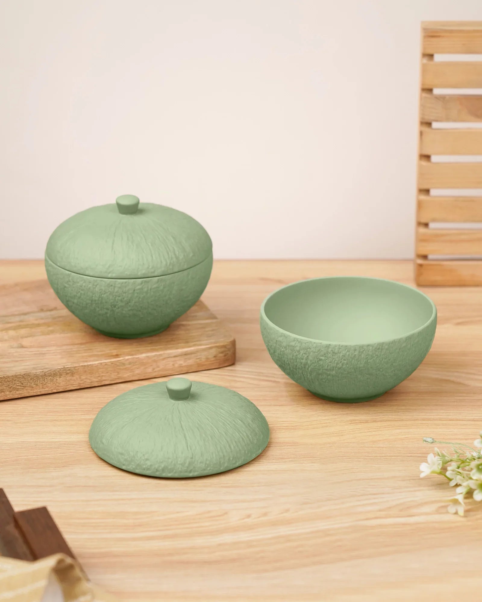 Premium green textured porcelain bowls with lids from Vola Global on a wooden table