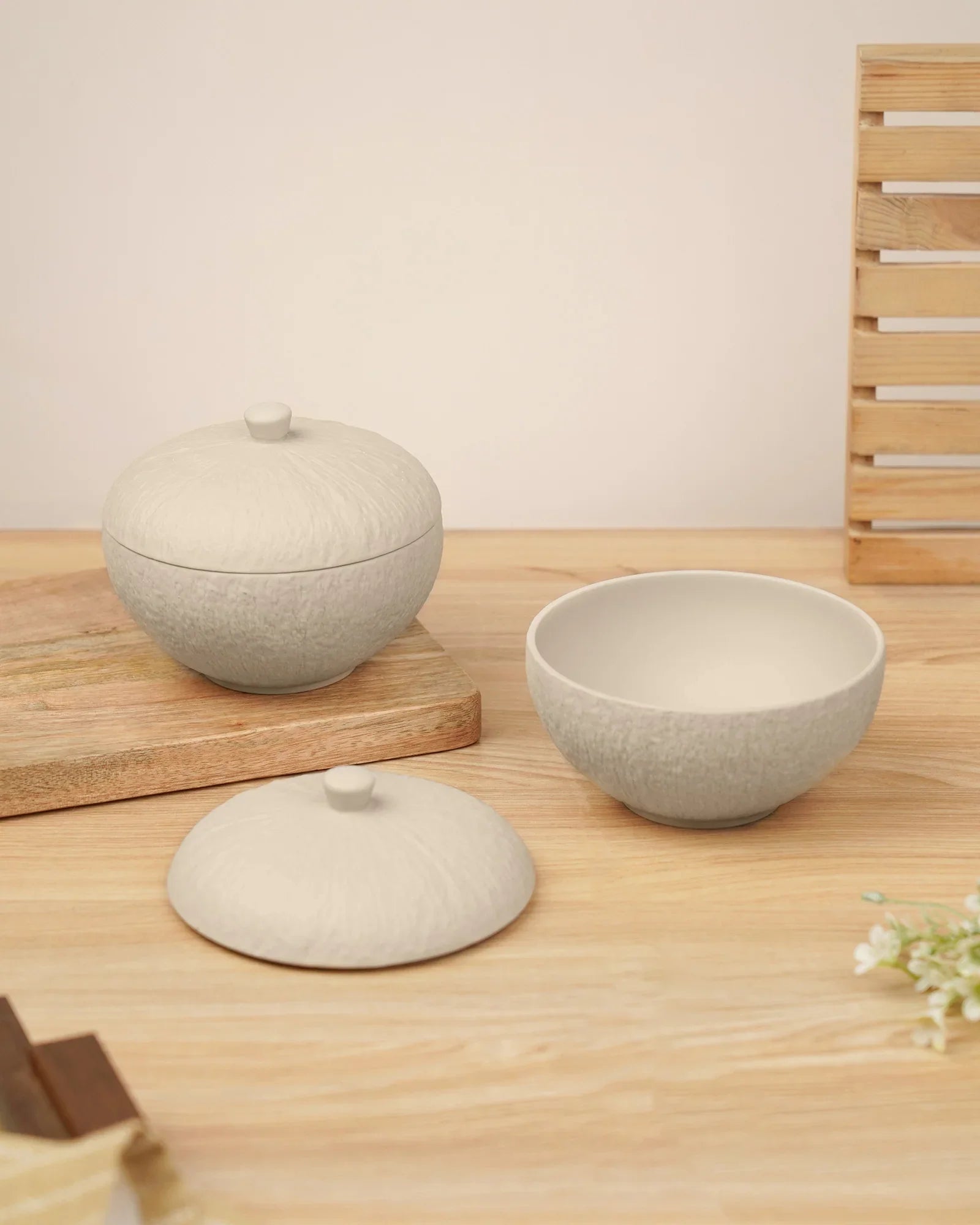 Minimalist porcelain bowls with textured lids on wooden table, premium crockery by Vola Global